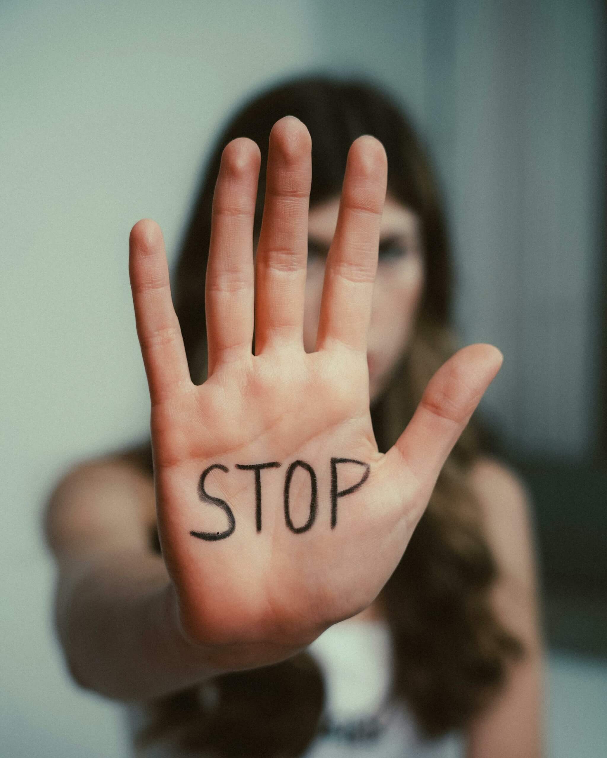 Femme présentant sa main avec un STOP écrit